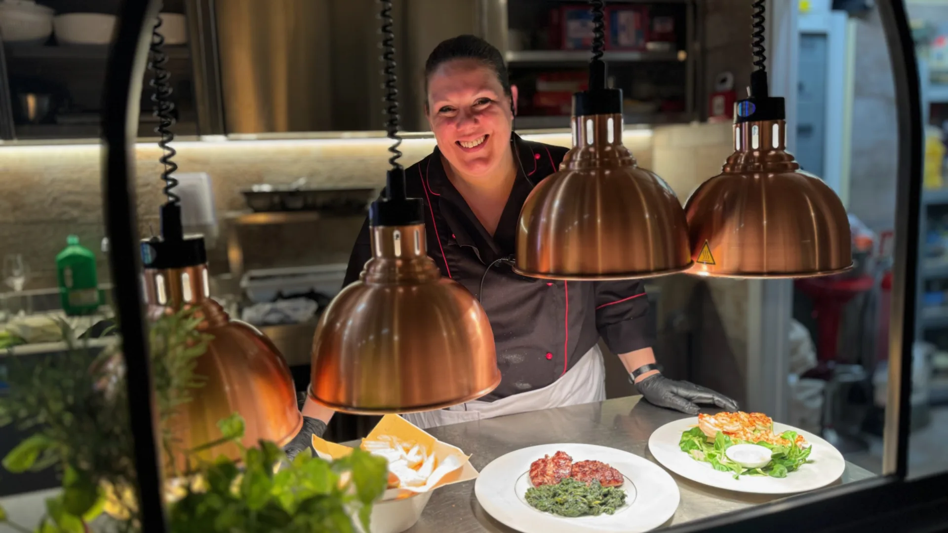La chef della Hosteria al pass della cucina a vista