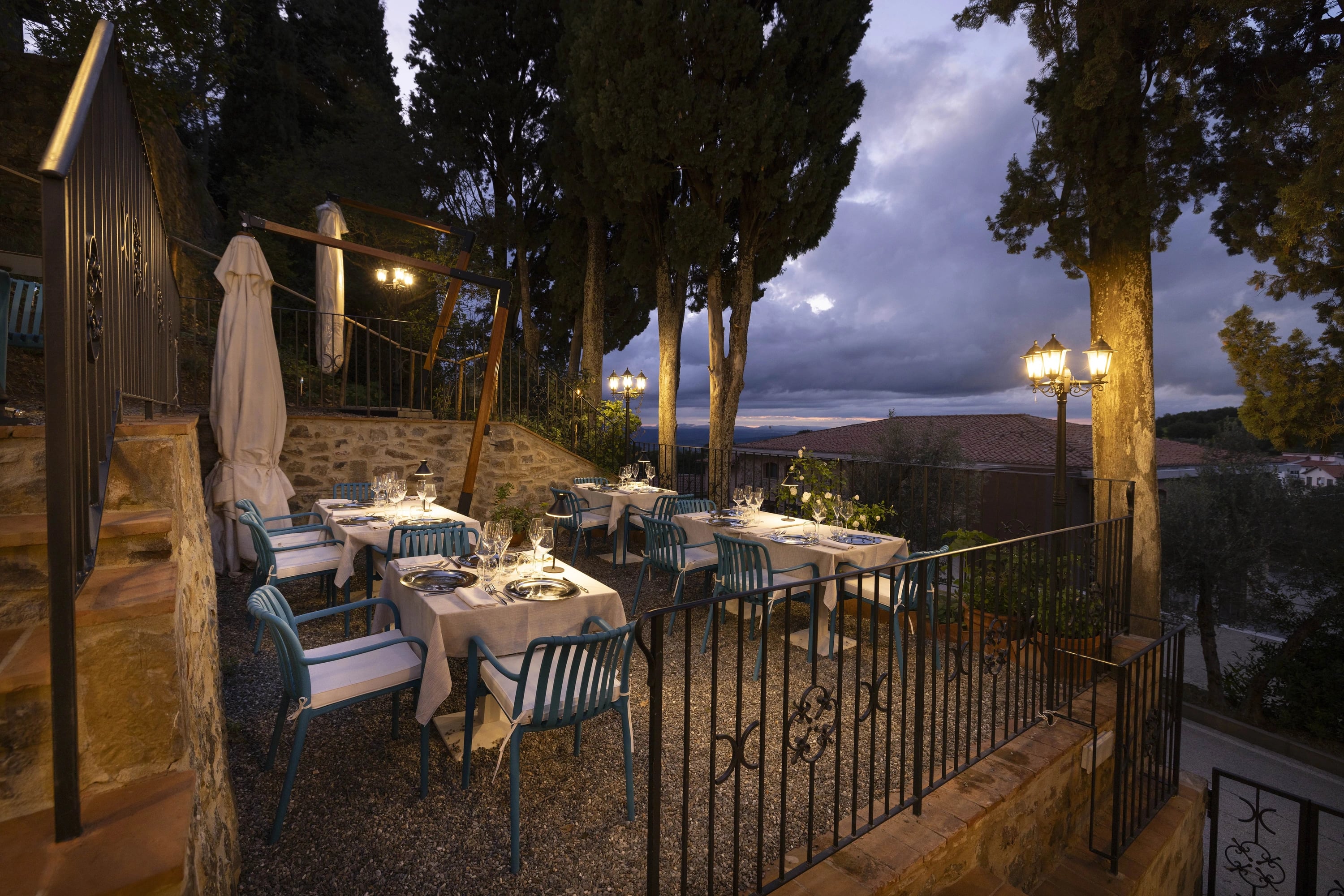 La terrazza nel giardino della Hosteria La Togata affacciata sulle colline toscane al crepuscolo