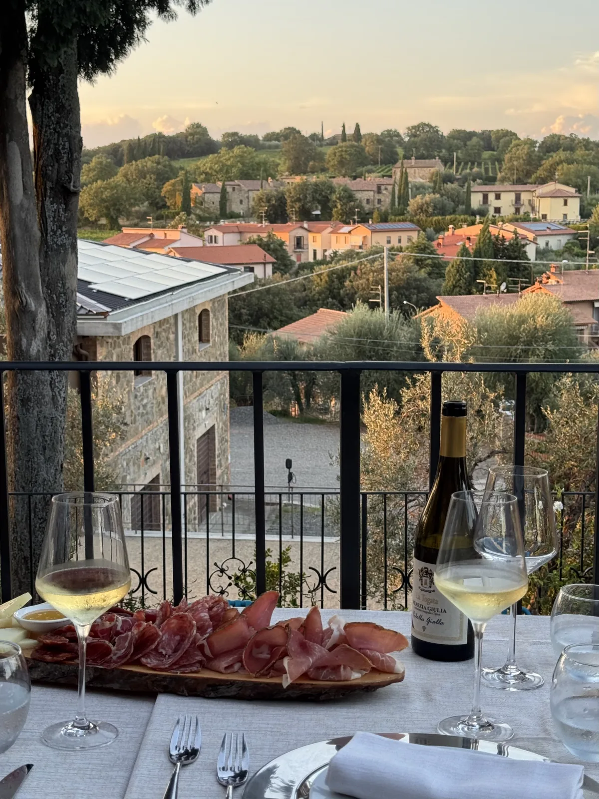 Tagliere di salumi e vino sulla terrazza affacciata sulle colline toscane